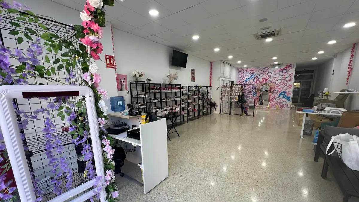 Interior de la tienda AmOr: mostrador, estanterías de productos y pared de corazones pintados